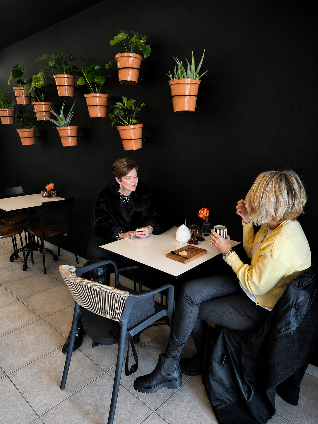 Guests enjoying coffee against the plant wall